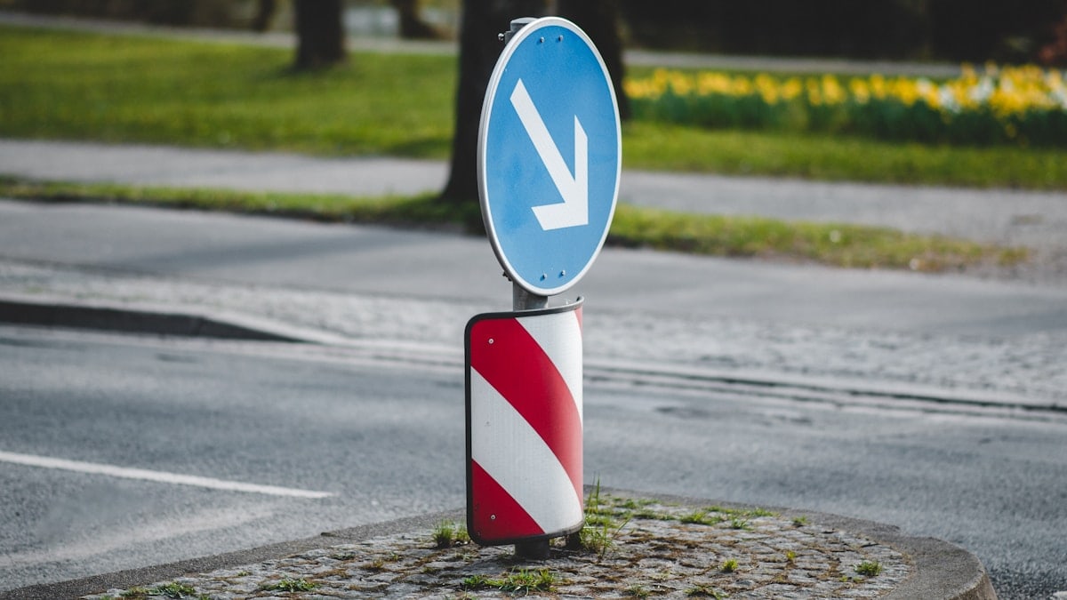 a blue and white sign sitting on the side of a road
